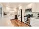 Modern kitchen featuring white cabinets, stainless steel appliances, subway tile backsplash, and hardwood floors at 1465 S Urban Way, Lakewood, CO 80228