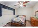 Cozy bedroom with a ceiling fan, window with blinds and a colorful patchwork quilt at 8731 W 89Th Pl, Broomfield, CO 80021