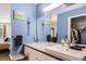 Bright bathroom featuring blue walls, white vanity, and decorative mirror at 10511 W 101St Ave, Broomfield, CO 80021