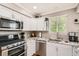 Bright kitchen featuring stainless steel appliances, granite countertops, and white cabinetry at 10511 W 101St Ave, Broomfield, CO 80021