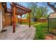 Landscaped backyard with a pergola over a patio and lush greenery at 1312 Ash St, Denver, CO 80220