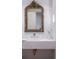 Elegant bathroom features a designer mirror, white stone sink and gold fixtures at 181 Race St, Denver, CO 80206
