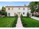 Stunning two-story home featuring a well-manicured front yard, red brick walkway, and a classic stucco facade at 181 Race St, Denver, CO 80206