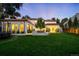 Expansive home with a manicured lawn, lush landscaping, and inviting lighting highlighting its impressive architecture at 181 Race St, Denver, CO 80206