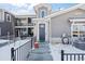 Entrance to gray townhome with stone accents, black door and wrought iron fence on a snowy day at 350 High Point Dr # C201, Longmont, CO 80504