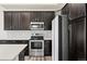 Modern kitchen featuring dark wood cabinets, stainless steel appliances, and a light gray subway tile backsplash at 350 High Point Dr # C201, Longmont, CO 80504