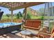 Covered patio features a hot tub, seating, and a view of the landscaped yard at 4077 Forever Cir, Castle Rock, CO 80109