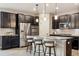 Open kitchen with stainless appliances, dark cabinetry, granite countertops, and seating at the island at 4077 Forever Cir, Castle Rock, CO 80109