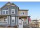 Two-story townhome with gray and beige siding, front porch, and American flag at 2932 Low Meadow Blvd, Castle Rock, CO 80109