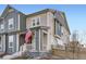 Two-story townhome with gray and beige siding, a front porch, and American flag at 2932 Low Meadow Blvd, Castle Rock, CO 80109