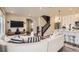 Open living space with sectional sofa, kitchen island, and staircase at 2932 Low Meadow Blvd, Castle Rock, CO 80109
