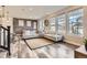 Spacious living room with L-shaped sofa, brick accent wall, and wood-look floors at 2932 Low Meadow Blvd, Castle Rock, CO 80109