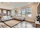 L-shaped sofa, wood-look floors, brick feature wall, and large windows at 2932 Low Meadow Blvd, Castle Rock, CO 80109