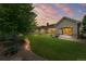 Expansive backyard featuring lush greenery, a manicured lawn, and inviting patio area with a cozy firepit at 14310 Inca St, Westminster, CO 80023