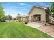 Landscaped backyard with green lawn, stone patio, and inviting outdoor seating area at 14310 Inca St, Westminster, CO 80023