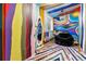 A colorful playroom with unique painted walls, a cozy black chair, and a vibrant striped rug at 14310 Inca St, Westminster, CO 80023