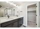 Modern bathroom featuring double sinks, quartz countertops, and a glass-enclosed shower at 21142 E 63Rd Dr, Aurora, CO 80019