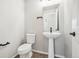 Modern half-bathroom with a pedestal sink, sleek fixtures, and clean, minimalist design at 21142 E 63Rd Dr, Aurora, CO 80019