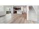 Open-concept living space with wood floors, seamlessly connecting the living room, kitchen, and staircase at 21142 E 63Rd Dr, Aurora, CO 80019