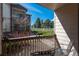 Relaxing balcony view overlooking lush greenery, a wooden fence, and a neighbor's unit at 8775 W Berry Ave # 101, Littleton, CO 80123
