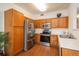 Well-equipped kitchen with stainless steel appliances, wood cabinets, and ample counter space at 8775 W Berry Ave # 101, Littleton, CO 80123