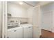 Functional laundry room with a washer and dryer set, shelving for storage, and ample space for laundry tasks at 8775 W Berry Ave # 101, Littleton, CO 80123