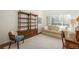 Bright living room with a cozy couch, wooden bookcase, and ample natural light from a large window at 8775 W Berry Ave # 101, Littleton, CO 80123