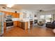 Open-concept kitchen and living room with fireplace, wood floors, and modern design, ideal for comfortable living at 8775 W Berry Ave # 101, Littleton, CO 80123