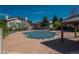 Community pool covered for the off-season, surrounded by trees and houses with pool house in the corner at 8775 W Berry Ave # 101, Littleton, CO 80123