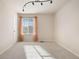 An empty bedroom featuring a ceiling light fixture, window and neutral colors at 3565 E 140Th Pl, Thornton, CO 80602