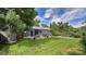 Expansive backyard with lush lawn, brick patio featuring an umbrella-covered dining set, and mature trees at 12020 W Alabama Pl, Lakewood, CO 80228