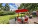 Landscaped backyard features a large, well-maintained lawn and an inviting patio with a dining area under a red umbrella at 12020 W Alabama Pl, Lakewood, CO 80228