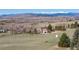 Aerial view featuring home on sprawling acreage with trees, lush greenery, and picturesque mountain backdrop at 2610 W County Road 4, Berthoud, CO 80513