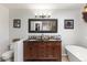 Bathroom with wood vanity, double sinks, dark countertop and a large mirror at 2610 W County Road 4, Berthoud, CO 80513