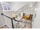 Bright staircase landing featuring a stained glass window and adjacent living area with bookshelves and bench seat at 2610 W County Road 4, Berthoud, CO 80513