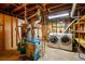 Unfinished basement featuring a furnace and adjacent laundry machines at 2448 S Leyden St, Denver, CO 80222