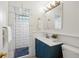 Bright bathroom featuring a modern vanity, decorative mirror, and shower with stylish tile work at 2448 S Leyden St, Denver, CO 80222