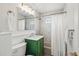 Charming bathroom with a green vanity, decorative tiles, and a shower with a tub at 2448 S Leyden St, Denver, CO 80222