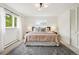 Well-lit bedroom with a large window, stylish rug, and comfortable bedding in a minimalist design at 2448 S Leyden St, Denver, CO 80222
