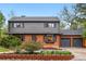 Charming two-story home with a brick and siding exterior, lush landscaping and a two car garage at 2448 S Leyden St, Denver, CO 80222