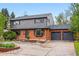 Beautifully landscaped home with a brick and siding exterior, a spacious driveway, and a two-car garage at 2448 S Leyden St, Denver, CO 80222