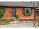 Beautiful brick home featuring a stylish front door, bay window, and manicured landscaping at 2448 S Leyden St, Denver, CO 80222
