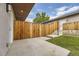 Private backyard with wooden fence, grassy area, and concrete patio at 2008 Galapago, Denver, CO 80223