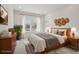 Bedroom featuring a large window, wood furniture, and a comfortable queen-sized bed with decorative straw accents at 3197 Cool Meadow Pl, Castle Rock, CO 80104