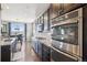 Modern kitchen featuring stainless steel appliances, dark cabinetry, granite countertops, and an adjacent dining area with scenic views at 3197 Cool Meadow Pl, Castle Rock, CO 80104