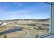 A window view of rolling hills, pond, and open space at 3197 Cool Meadow Pl, Castle Rock, CO 80104