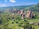 Stunning aerial of golf course, dramatic rock formations, and lush green landscape at 6980 Fargo Trl, Littleton, CO 80125