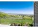Expansive backyard with lush green grass, a classic wood fence, and scenic views of the surrounding landscape at 6980 Fargo Trl, Littleton, CO 80125