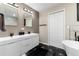 Modern bathroom with double vanity, large mirrors, and a stylish geometric tile floor at 6980 Fargo Trl, Littleton, CO 80125