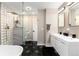 Elegant bathroom with double vanity, a frameless glass shower, and marble tile at 6980 Fargo Trl, Littleton, CO 80125